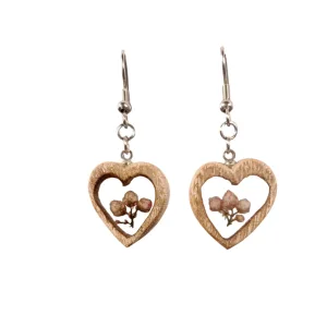 Par de brincos artesanais em forma de coração em madeira de olmo com pequenas flores secas em tons rosados, pendentes com gancho prateado.