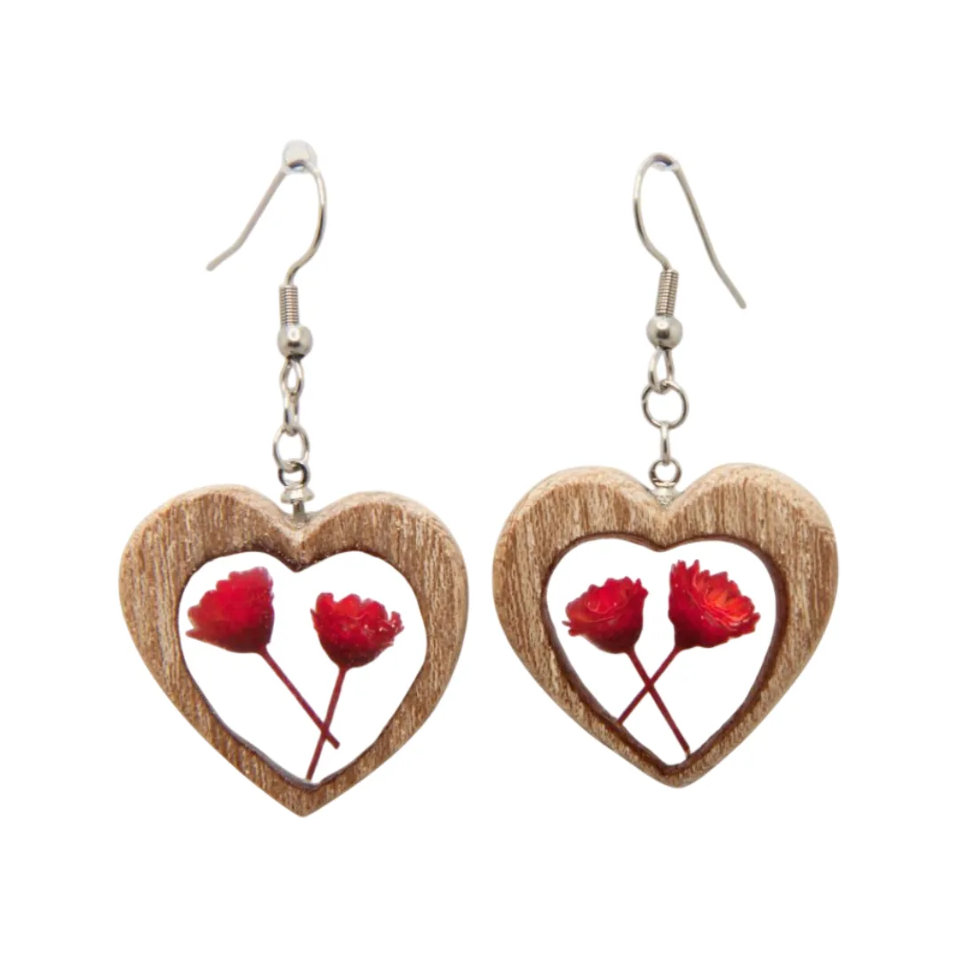 Par de brincos artesanais em forma de coração em madeira de olmo com flores vermelhas preservadas em resina, pendentes com gancho prateado.