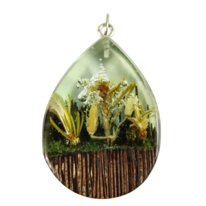 Pendente em forma de gota em madeira de wengué e resina transparente verde, com mini flores secas e efeito bolhas.