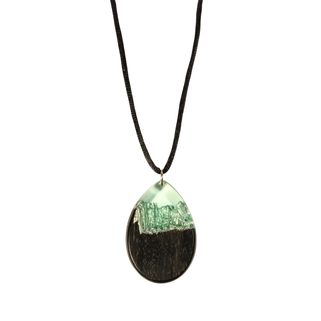 Colar com cordão preto e pendente gota em madeira de ébano e resina azul clara transparente com reflexos prateados