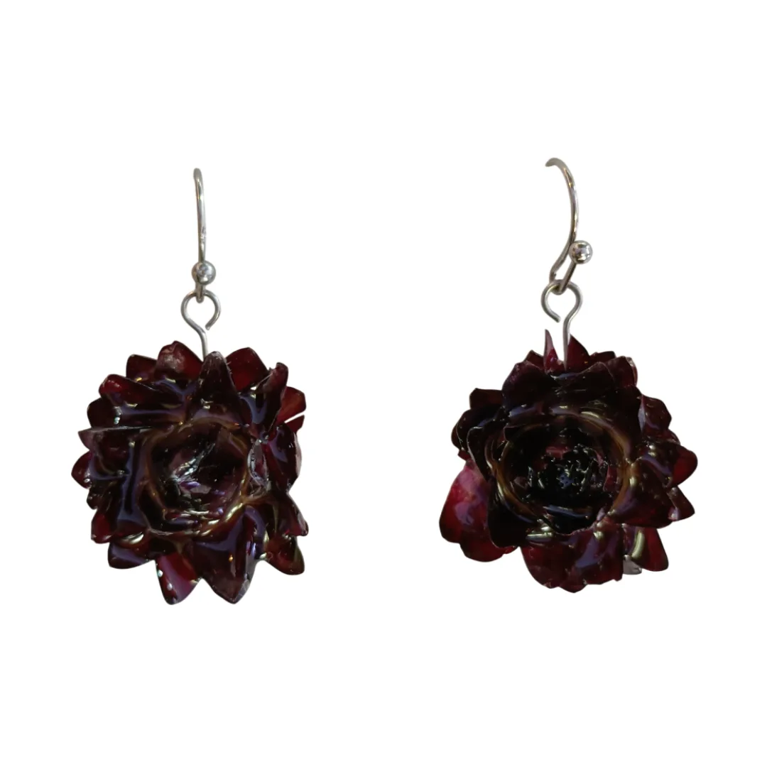 Par de brincos artesanais com flor natural Bordeaux preservada em resina, em forma de flor, com ganchos prateados e fundo branco.