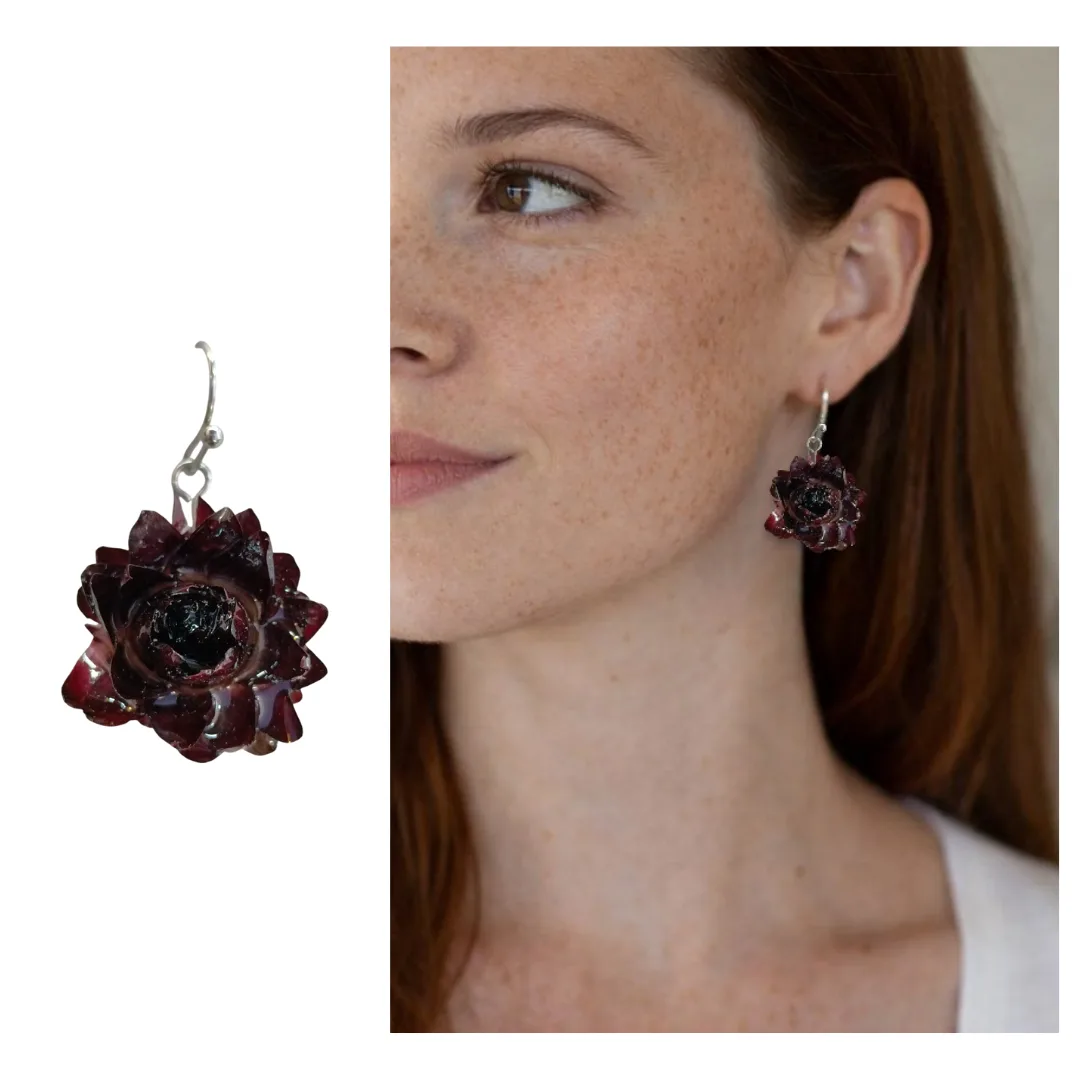Modelo a usar brinco com flor natural Bordeaux preservada em resina; brinco ampliado em destaque ao lado para mostrar os detalhes.
