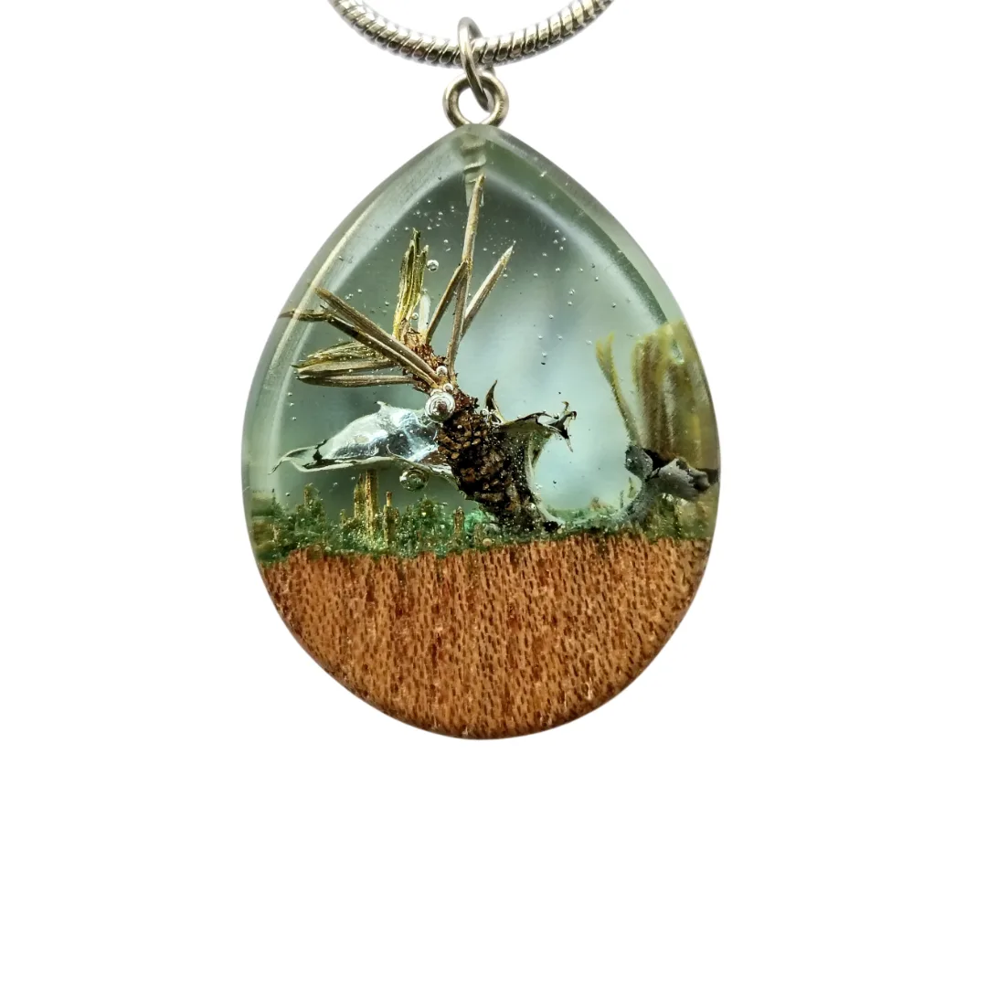 Detail of the drop pendant in elm wood and crystal resin, with natural inclusions and a polished finish.