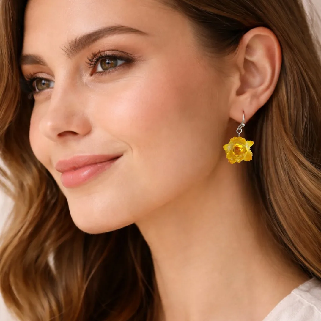 Mulher a usar os brincos Beijo de Sol com flor natural amarela preservada em resina