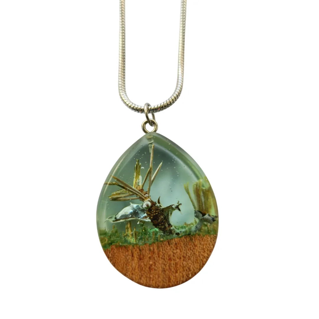 Drop pendant in elm wood and crystal resin with natural details, worn on the chest with stainless steel wire.