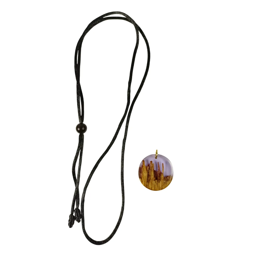 Adjustable necklace with black cord and round pendant in acacia wood and translucent lilac resin.