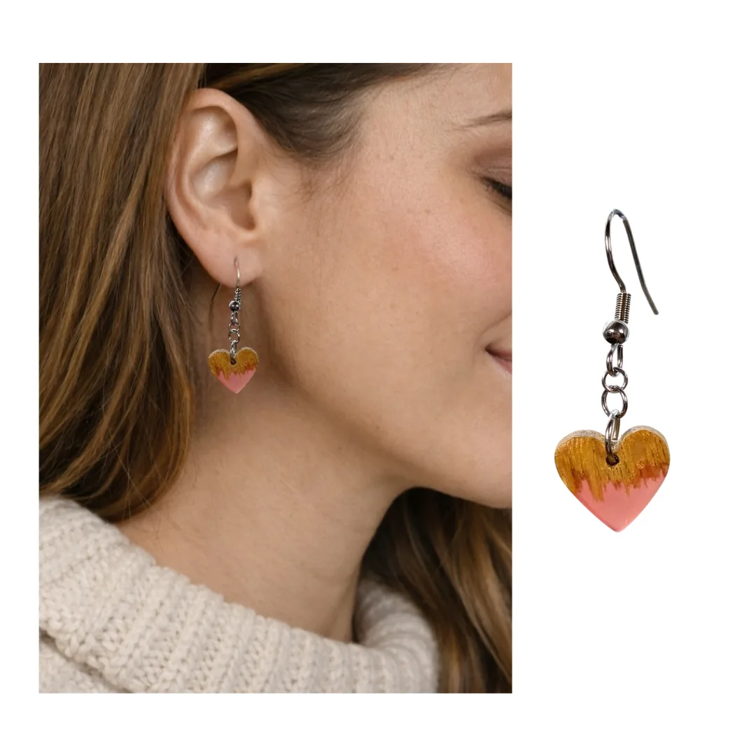 Modelo a usar brincos coração Cordis em madeira e resina rosa