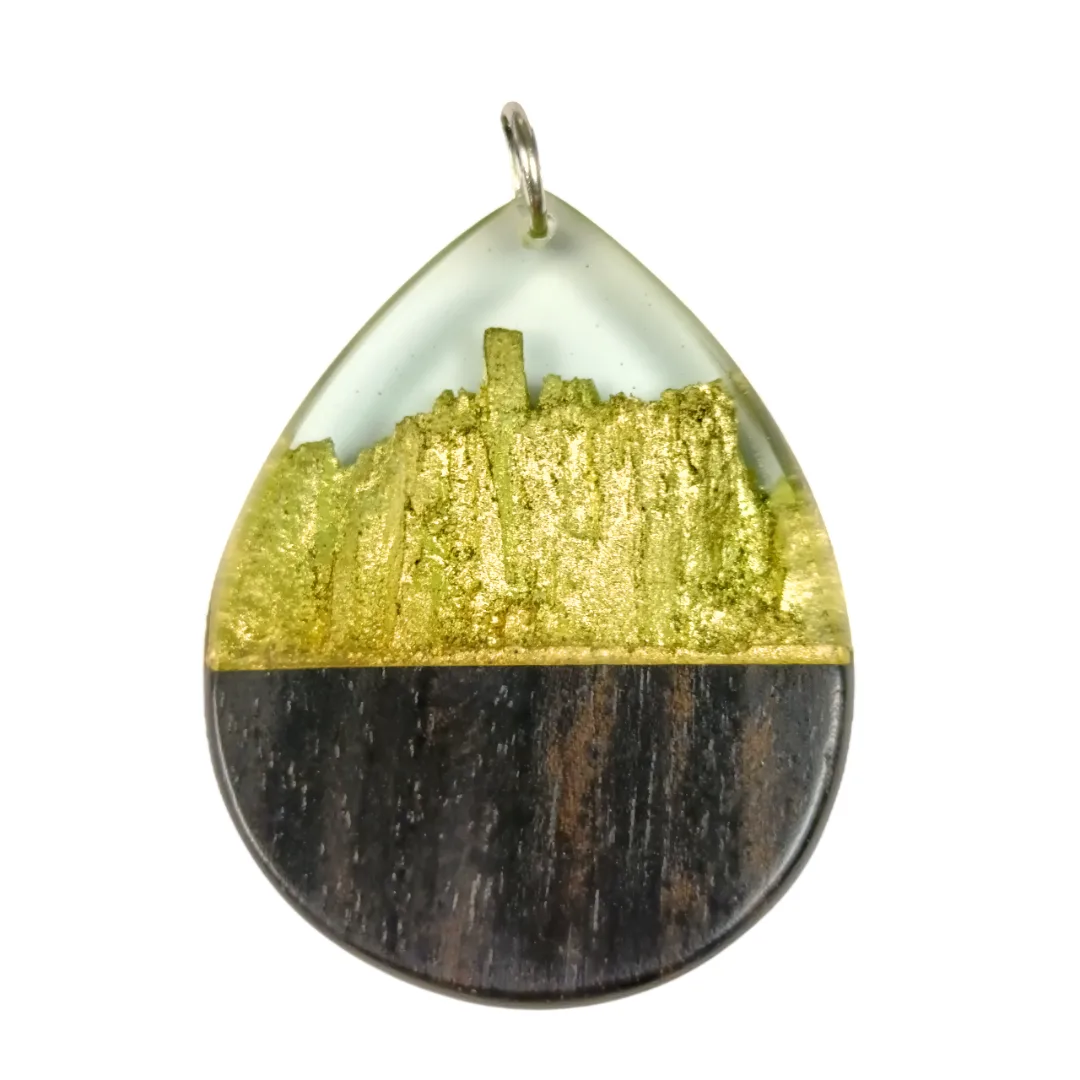 Pendente em forma de gota em madeira de ébano com folha de ouro e resina, fotografia de produto em fundo branco.
