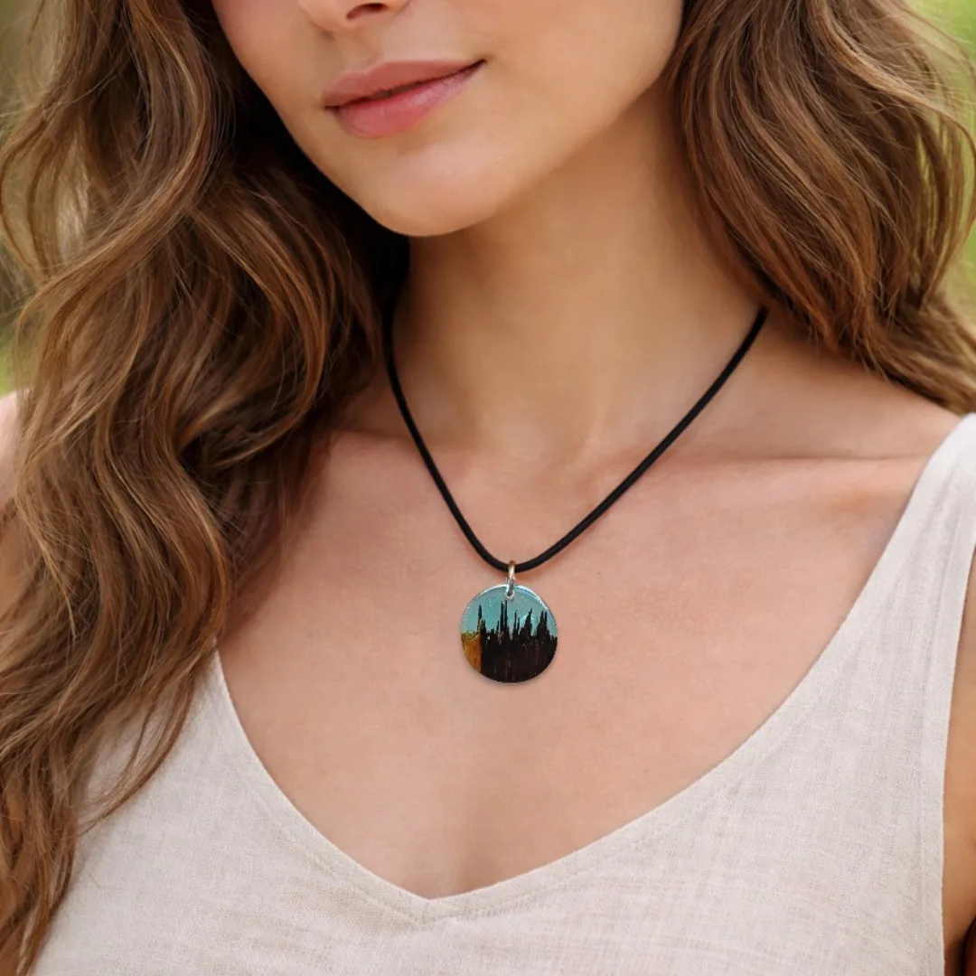Pendente redondo em madeira natural e resina azul turquesa com efeito paisagem noturna num modelo de cabelo comprido